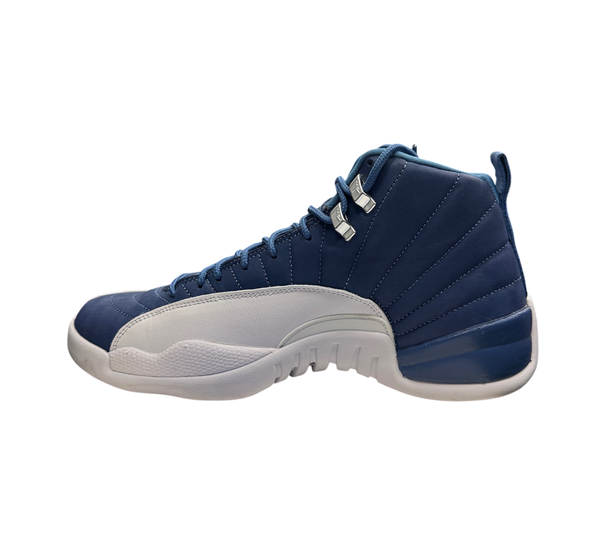 Genesis Boutique Jordan 12 Indigo sneakers in blue and white leather, side profile view in a retail store setting.