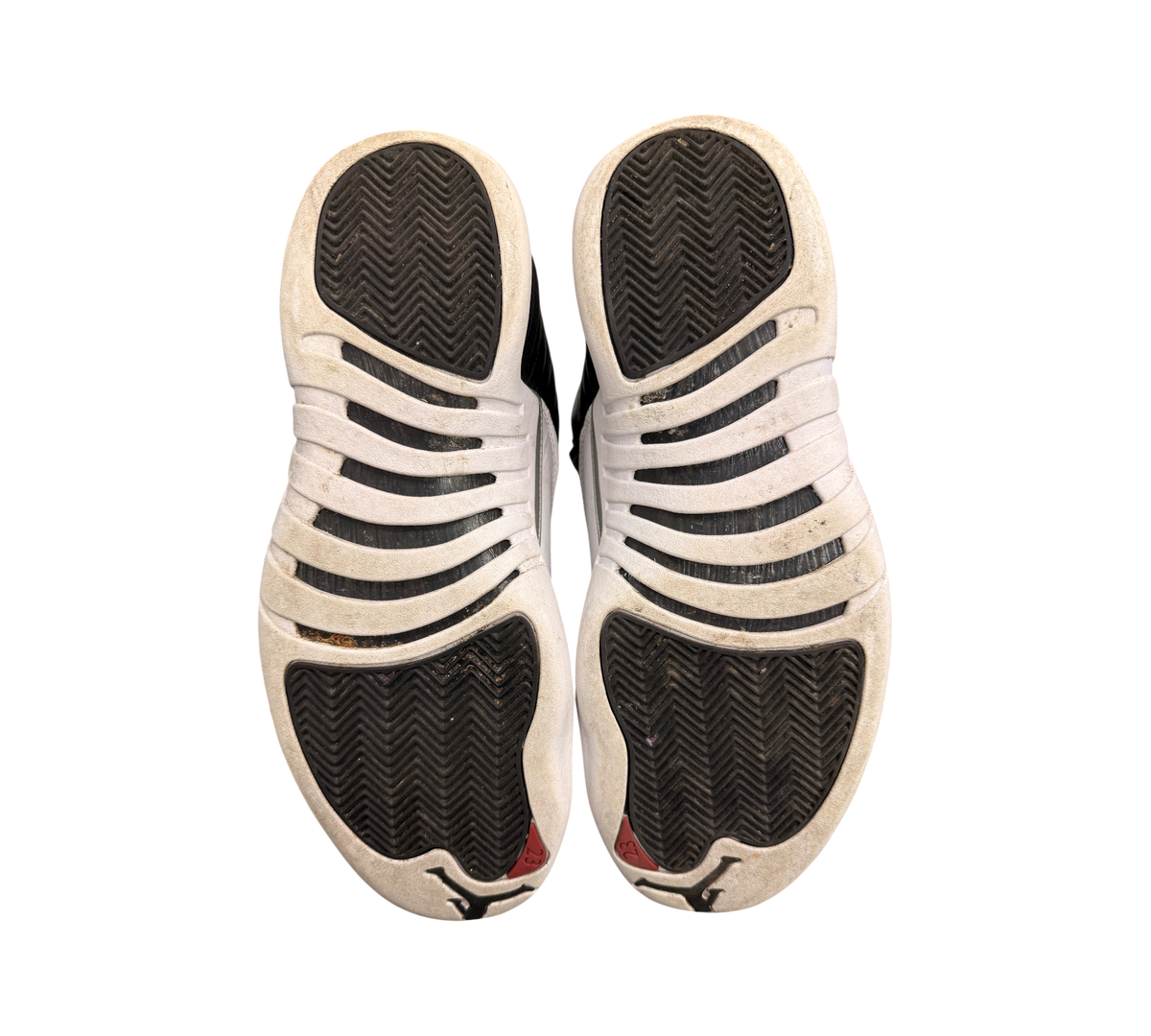 Genesis Boutique used Jordan 12 Playoff sneakers showing black and white herringbone traction outsoles