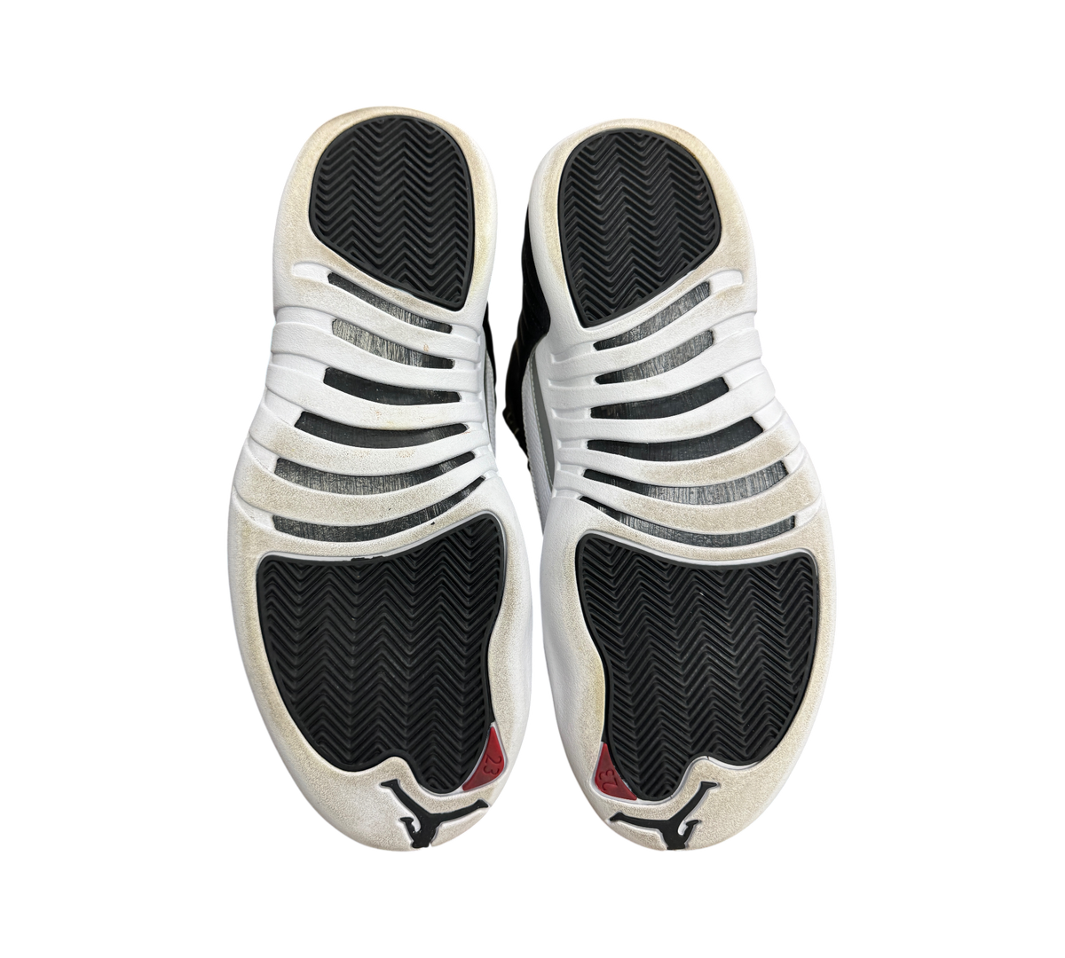 Genesis Boutique Jordan 12 Playoff sneakers showing the black and white rubber outsoles with herringbone traction