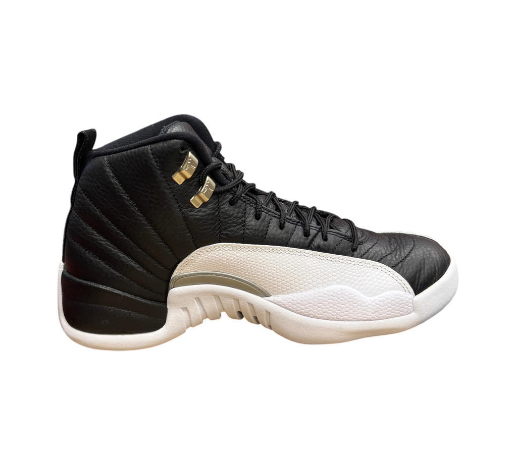 Genesis Boutique Jordan 12 Playoff sneakers in black and white leather with metallic gold eyelets on a shoe box.