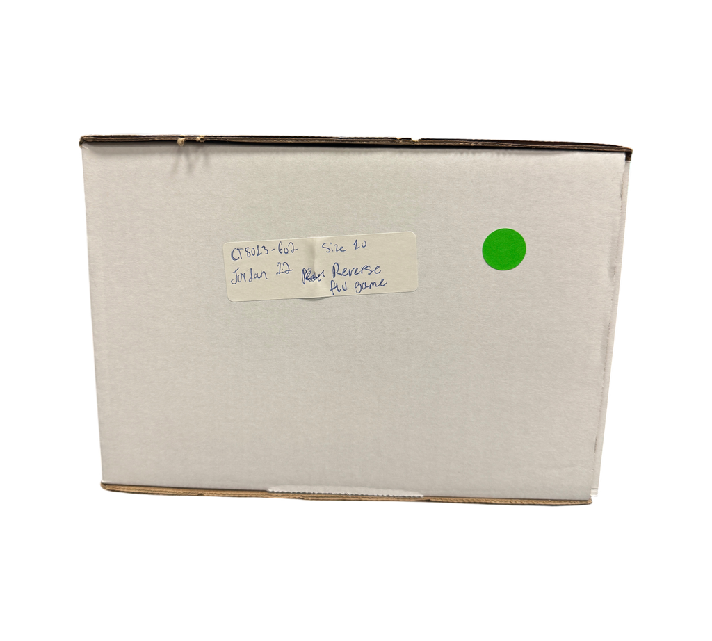 Genesis Boutique Jordan 12 Reverse Flu Game sneaker box with handwritten product label in a retail store setting