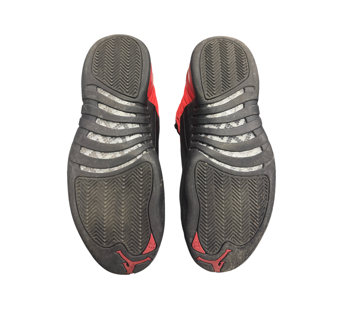 Genesis Boutique used Jordan 12 Reverse Flu Game sneakers showing black and red rubber outsoles with carbon fiber shank