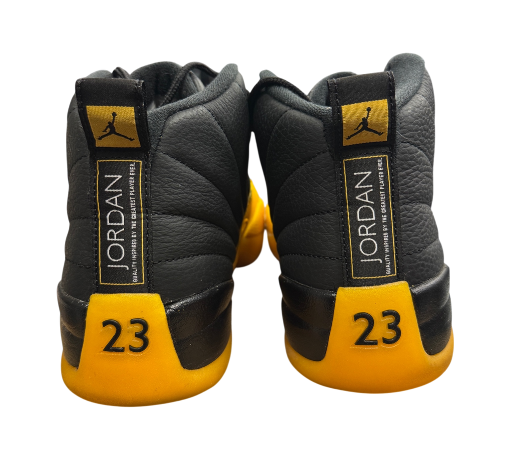 Genesis Boutique Jordan 12 University Gold sneakers featuring black leather and yellow accents with 23 heel branding