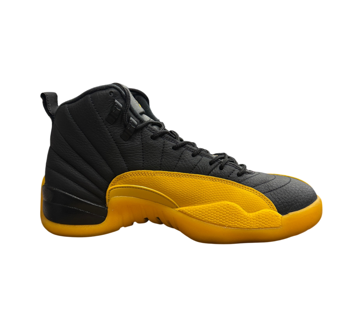 Genesis Boutique Jordan 12 University Gold sneakers featuring black leather upper and vibrant yellow textured mudguard
