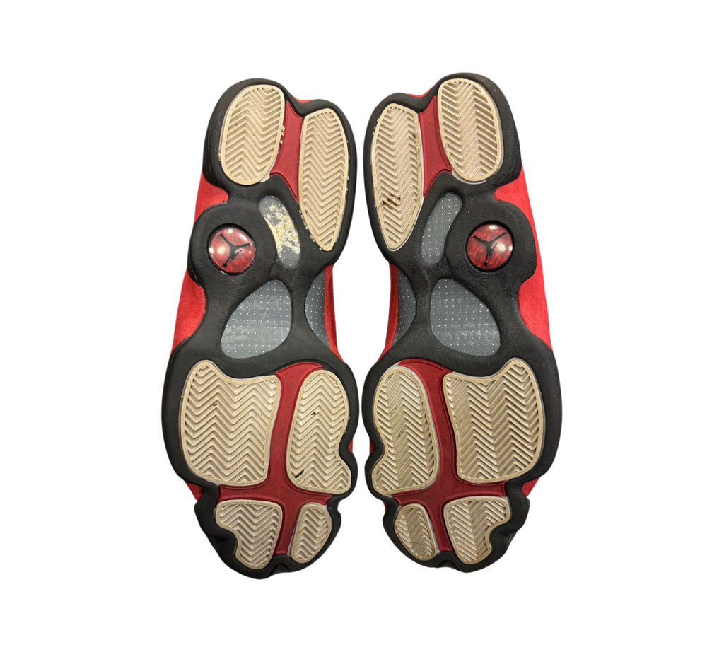 Genesis Boutique used Jordan 13 Chicago sneakers showing the red, white, and black patterned rubber outsoles.
