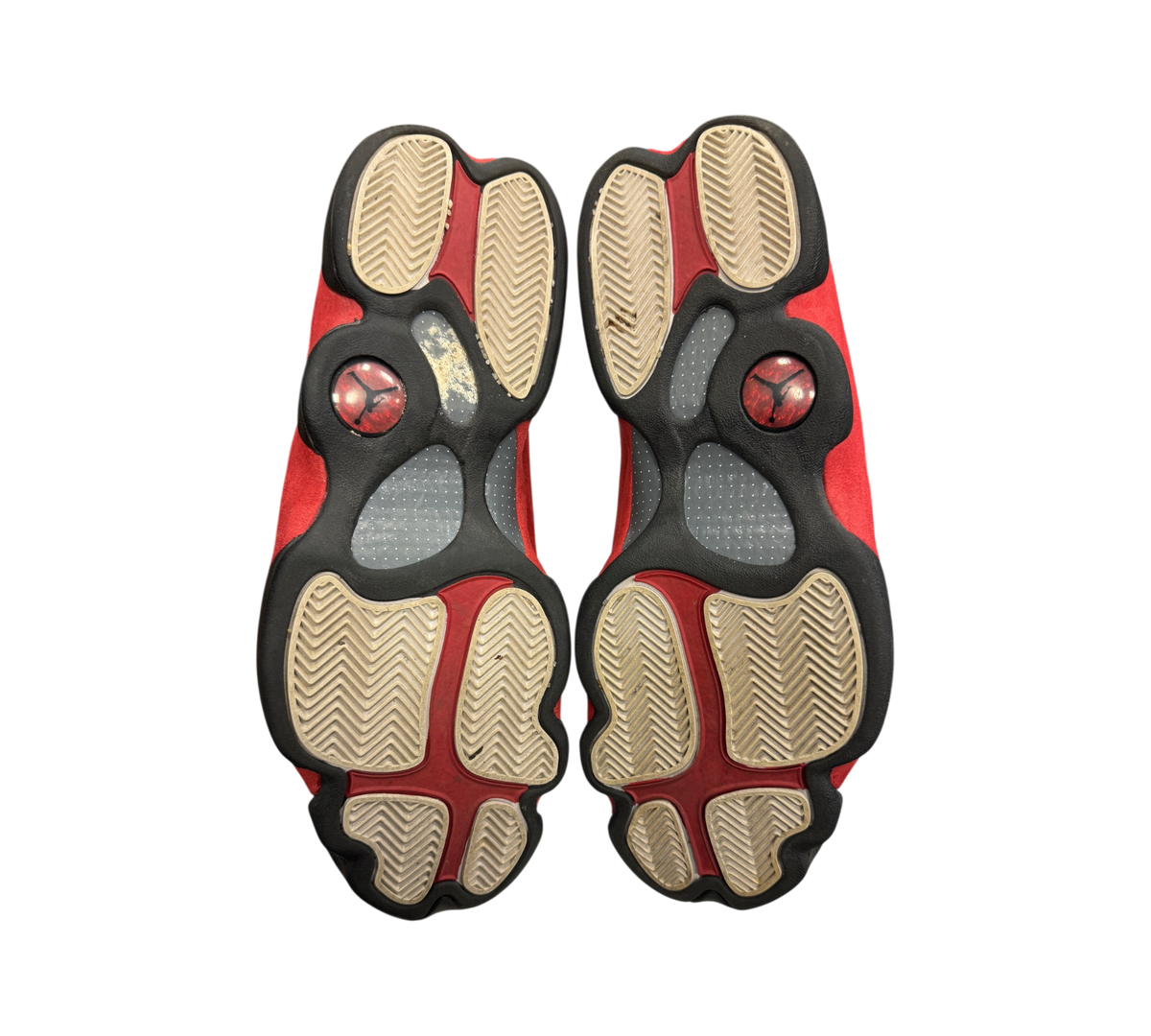 Genesis Boutique used Jordan 13 Chicago sneakers showing the red, white, and black patterned rubber outsoles.