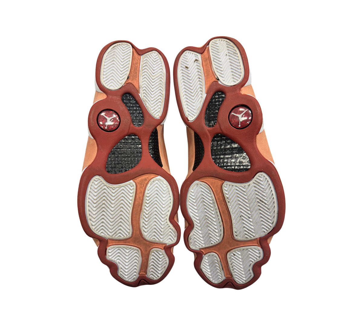Genesis Boutique Jordan 13 Dune Red sneakers showing the clean white and red patterned outsoles with Jumpman logos