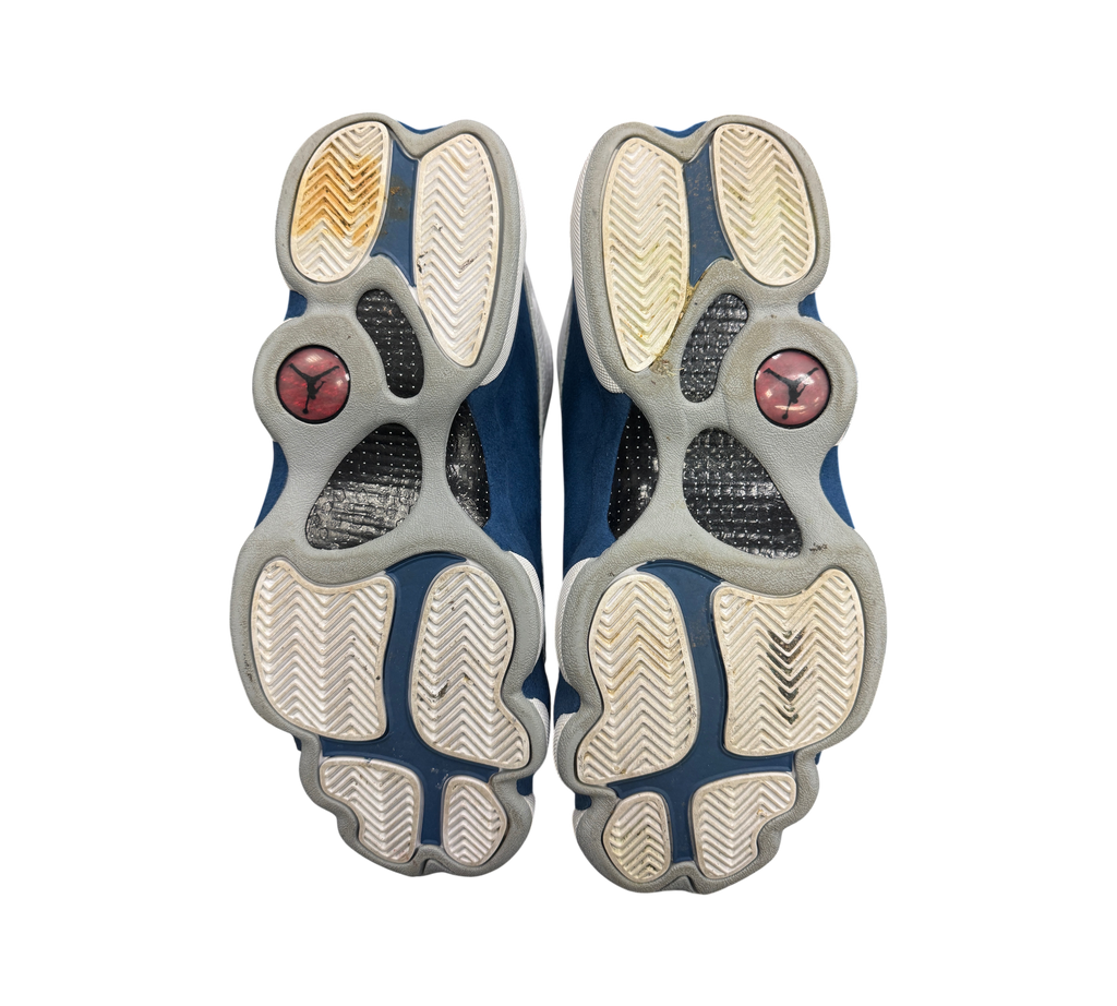 Genesis Boutique used Jordan 13 French Blue sneakers showing the white and blue rubber outsoles with Jumpman logos.