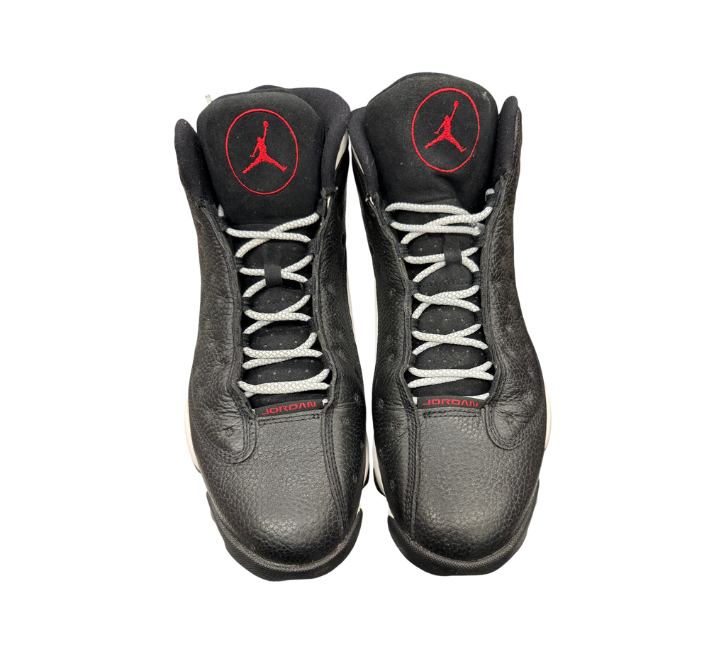 Genesis Boutique Jordan 13 Reverse He Got Game sneakers in black leather with red Jumpman logos and grey laces.