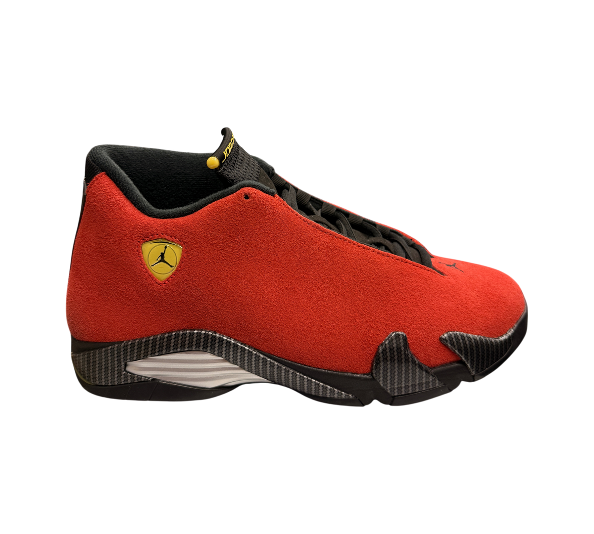 Genesis Boutique Jordan 14 Ferrari sneakers in red suede with black carbon fiber details and yellow Jumpman logo.