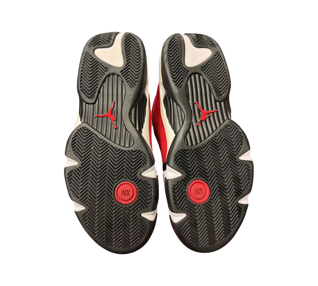 Genesis Boutique Jordan 14 Toro Bravo sneakers showing the black, white, and red rubber outsoles with Jumpman branding.
