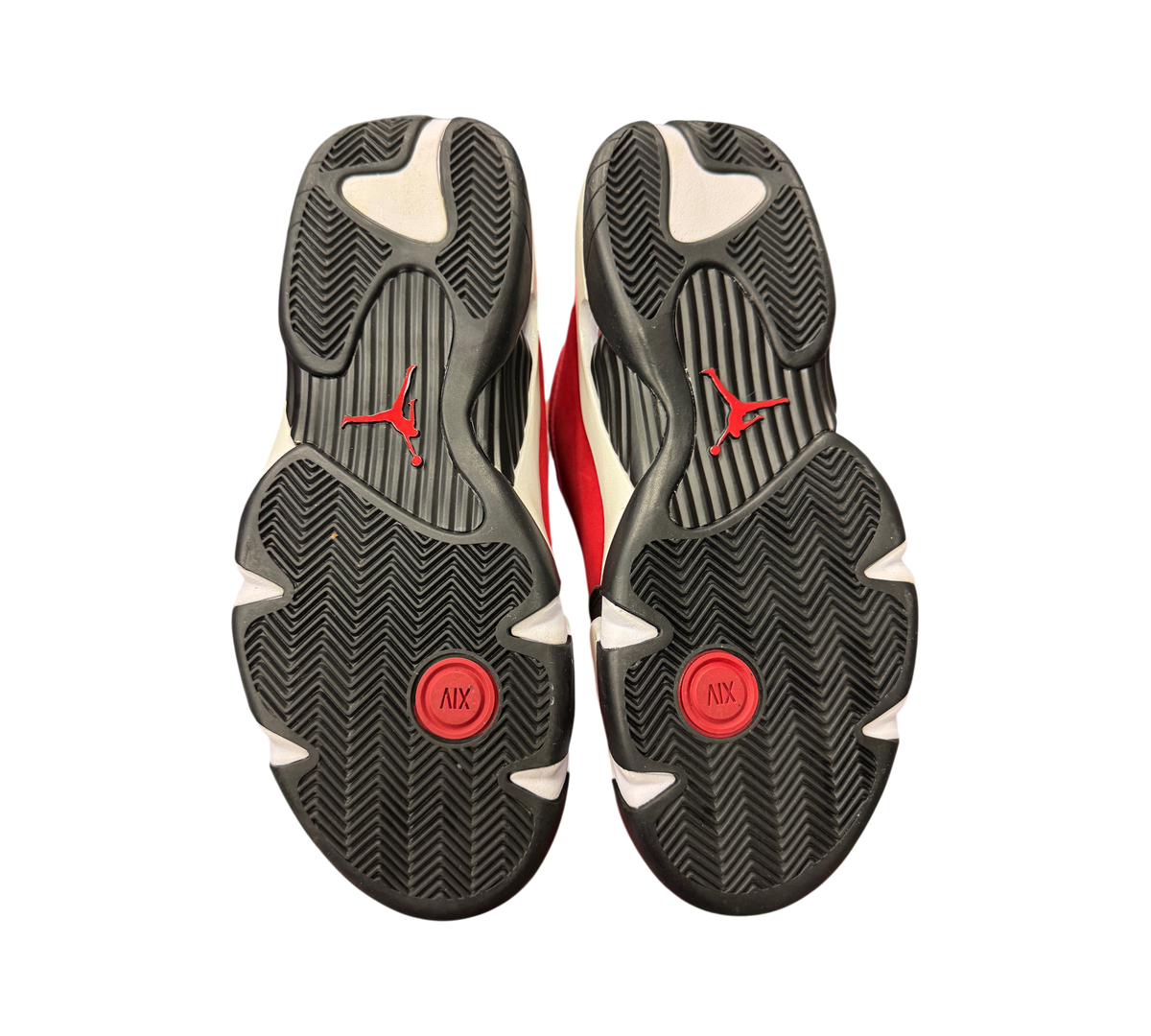 Genesis Boutique Jordan 14 Toro Bravo sneakers showing the black, white, and red rubber outsoles with Jumpman branding.