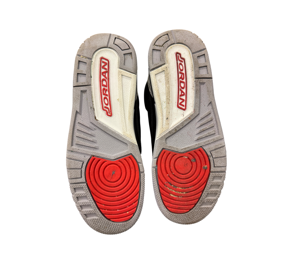 Genesis Boutique Jordan 3 GS Black Cement Reimagined sneakers showing grey and red rubber outsoles with Jordan logo