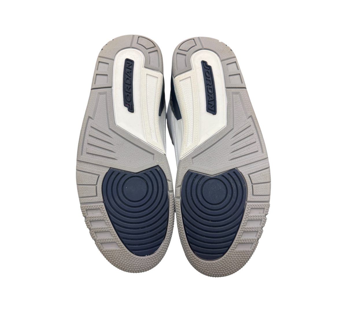 Genesis Boutique Jordan 3 Midnight Navy sneakers showing the grey and navy blue rubber outsoles with Jordan branding.