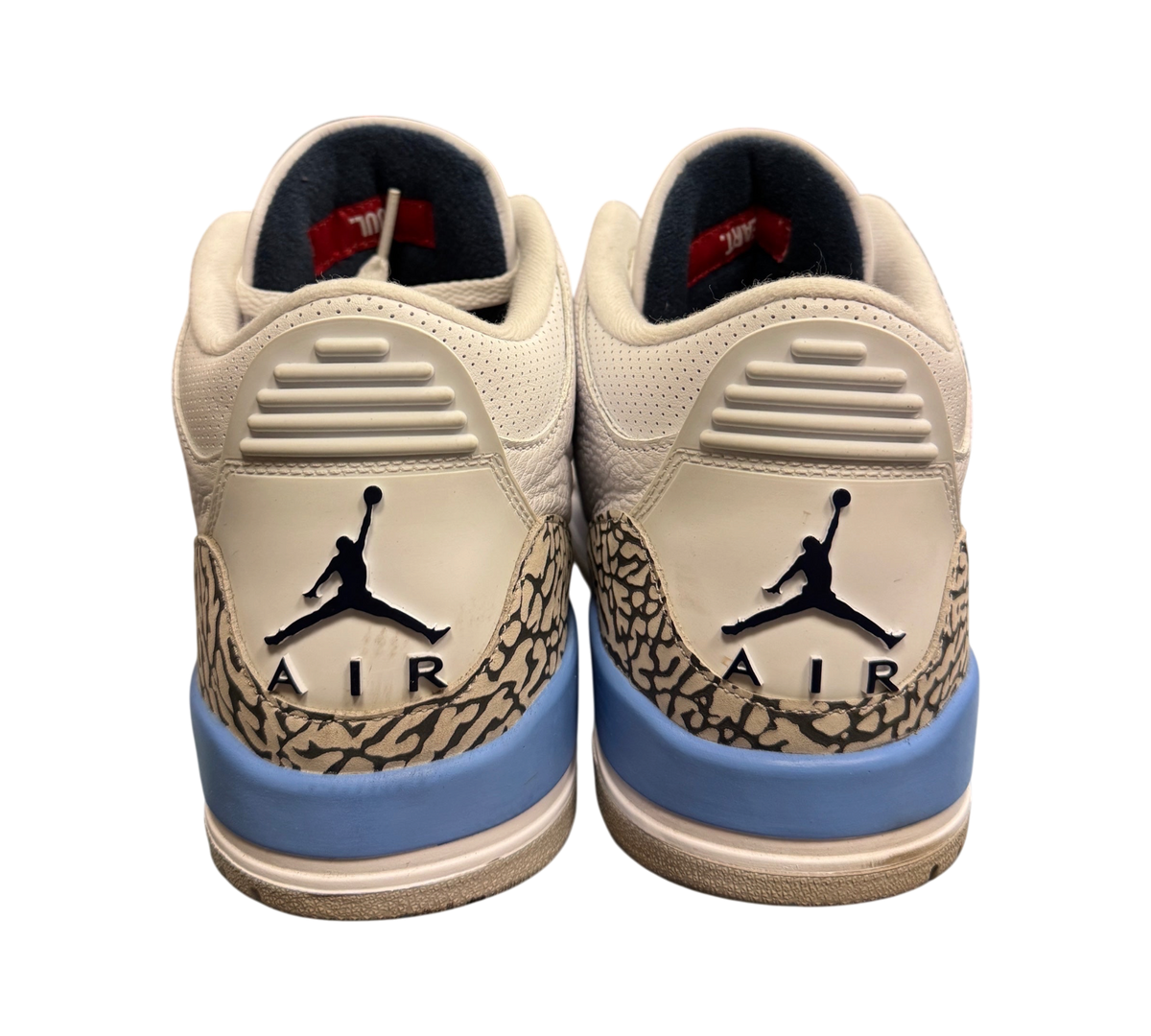 Genesis Boutique Jordan 3 UNC sneakers showing the white leather heel, elephant print, and blue midsole details.