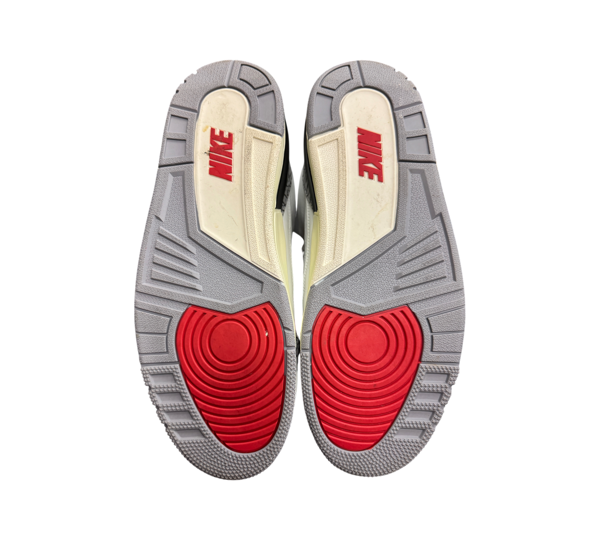 Genesis Boutique Jordan 3 White Cement Reimagined sneakers showing the grey, red, and off-white rubber outsoles.