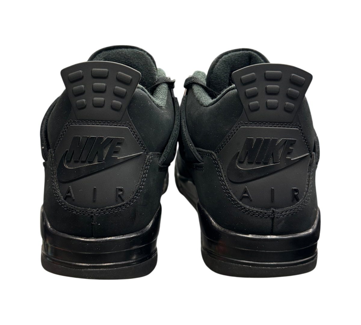Genesis Boutique Jordan 4 Black Cat sneakers showing the black heel tabs with Nike Air branding in a retail store.