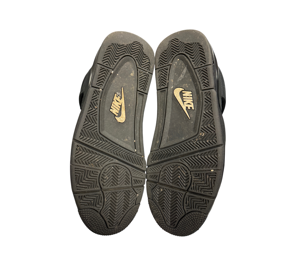 Genesis Boutique used Jordan 4 Black Cat sneakers showing the worn black rubber outsoles with Nike branding.