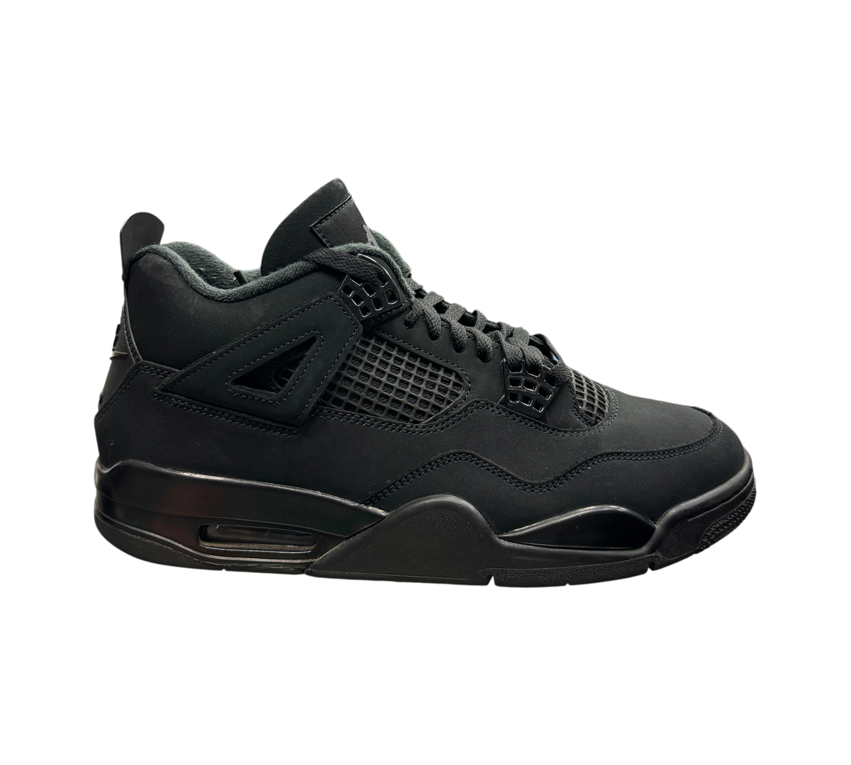 Genesis Boutique used Jordan 4 Black Cat sneakers in all-black nubuck leather on a glass display shelf.