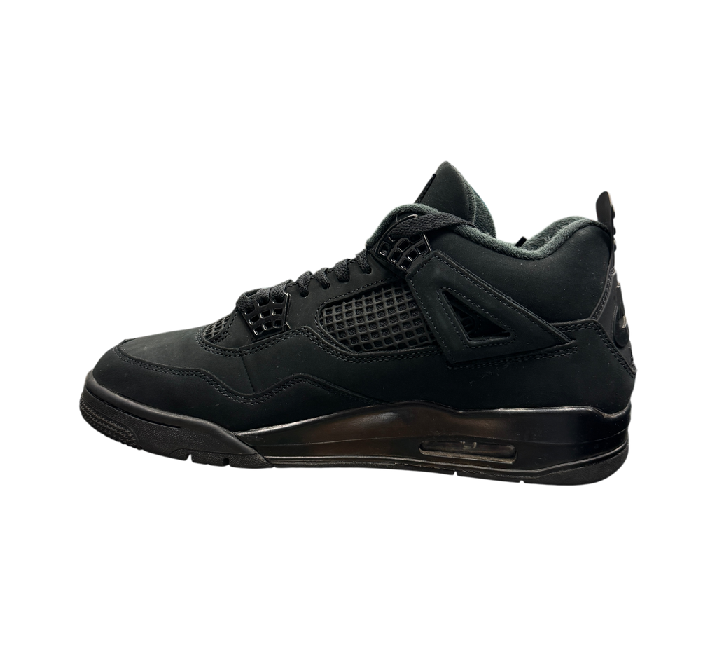 Genesis Boutique Jordan 4 Black Cat sneakers in all-black nubuck leather displayed on a glass shelf in a store.