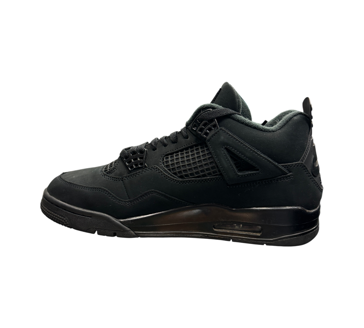 Genesis Boutique Jordan 4 Black Cat sneakers in all-black nubuck leather displayed on a glass shelf in a store.