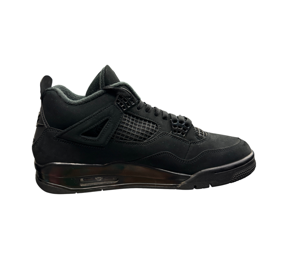 Genesis Boutique Jordan 4 Black Cat sneakers in all-black suede with mesh detailing displayed on a glass counter.