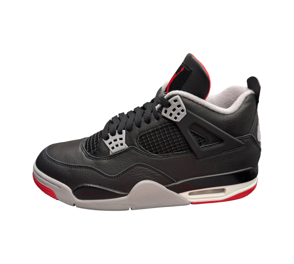 Genesis Boutique Jordan 4 Bred Reimagined sneakers in black leather with grey and red accents on a branded shoebox.