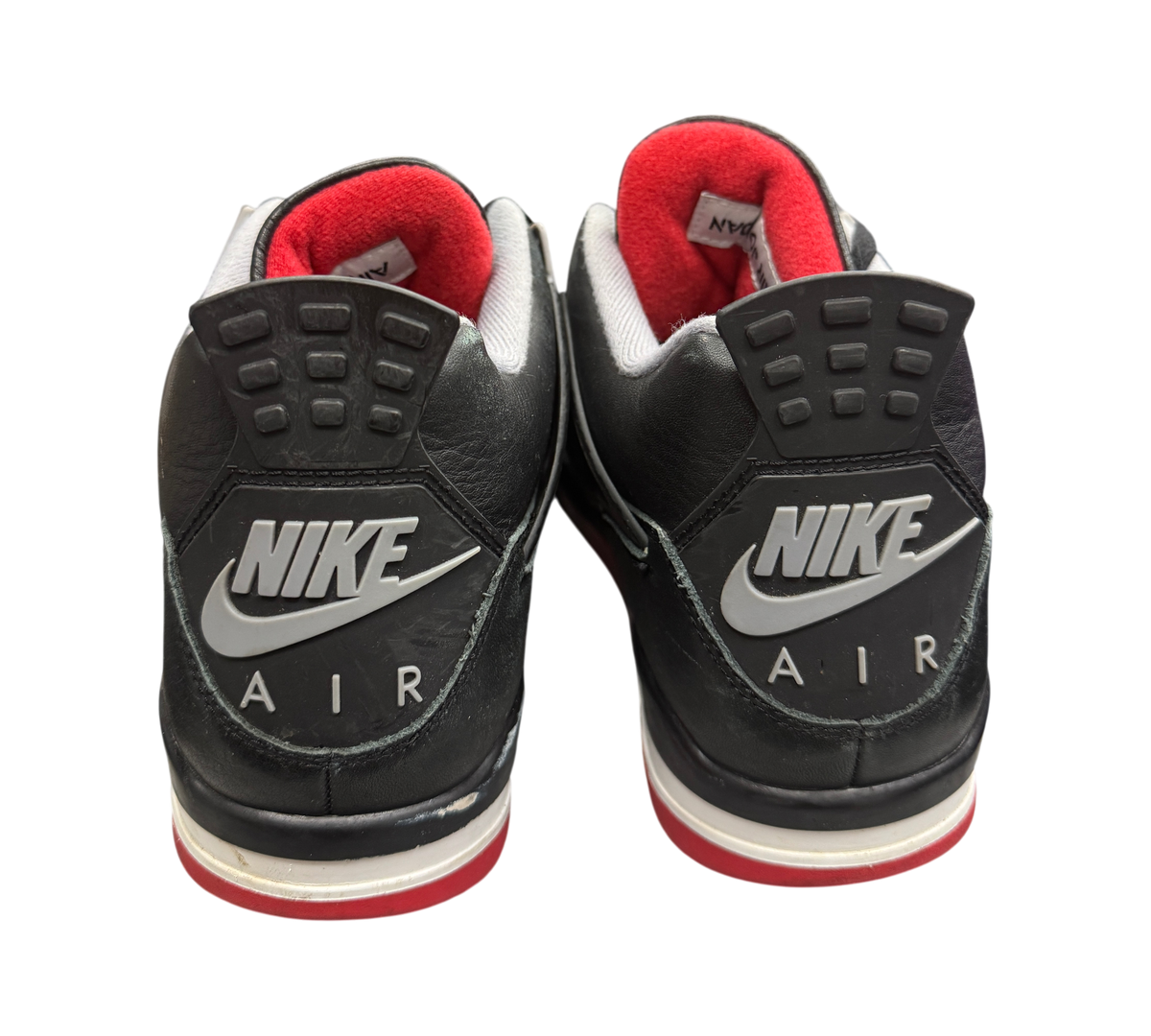 Genesis Boutique Jordan 4 Bred Reimagined sneakers showing black leather heels with Nike Air branding and red lining.