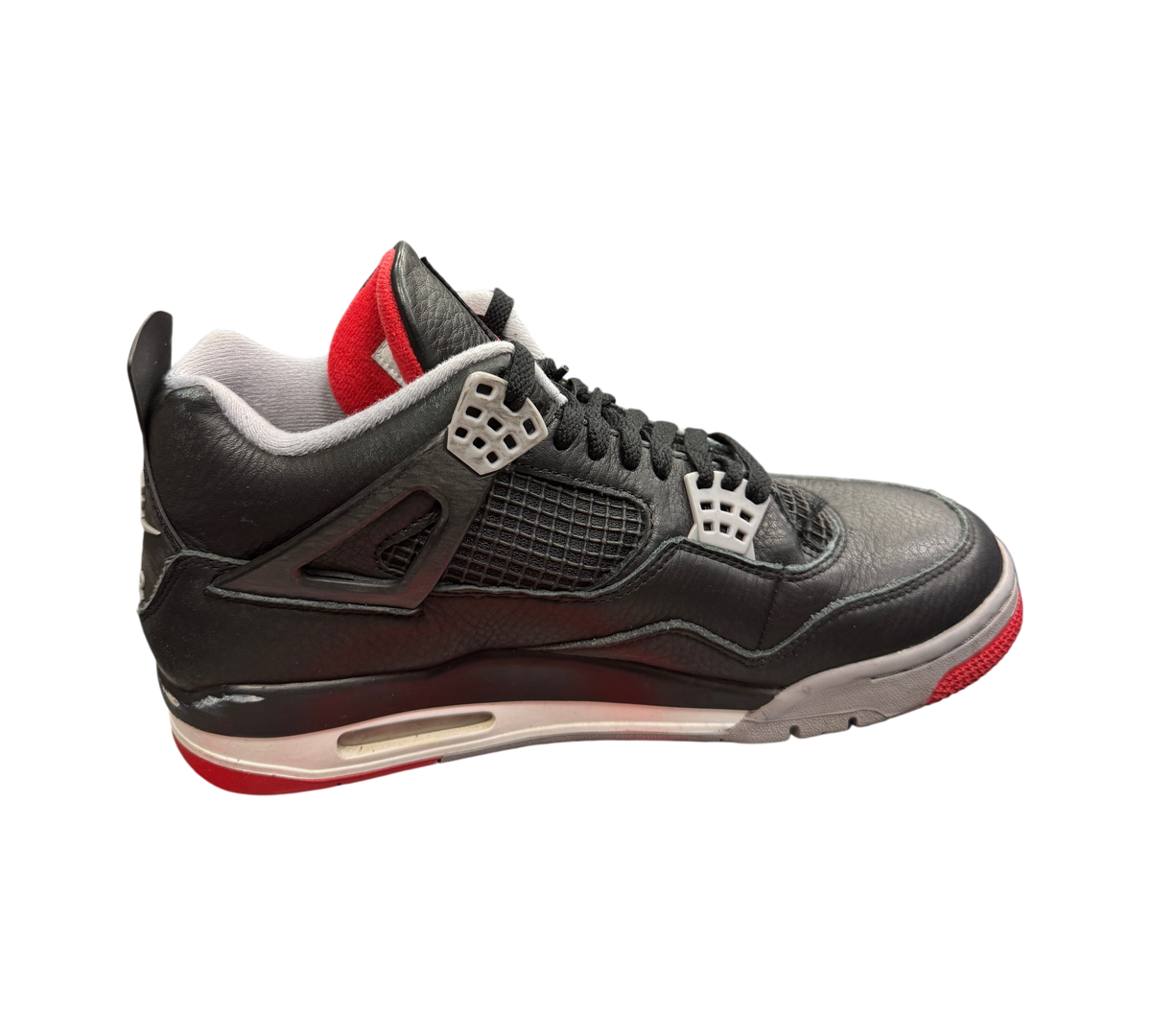 Genesis Boutique used Jordan 4 Bred Reimagined sneakers in black leather with red and grey accents on a display box.