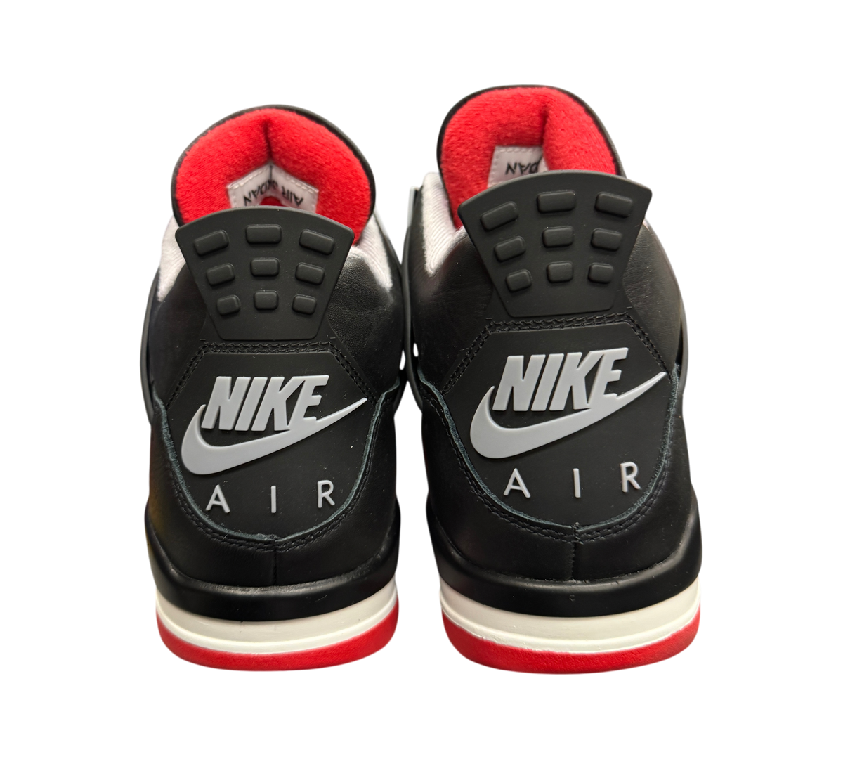 Genesis Boutique Jordan 4 Bred Reimagined sneakers featuring black leather heels with Nike Air branding and red accents.