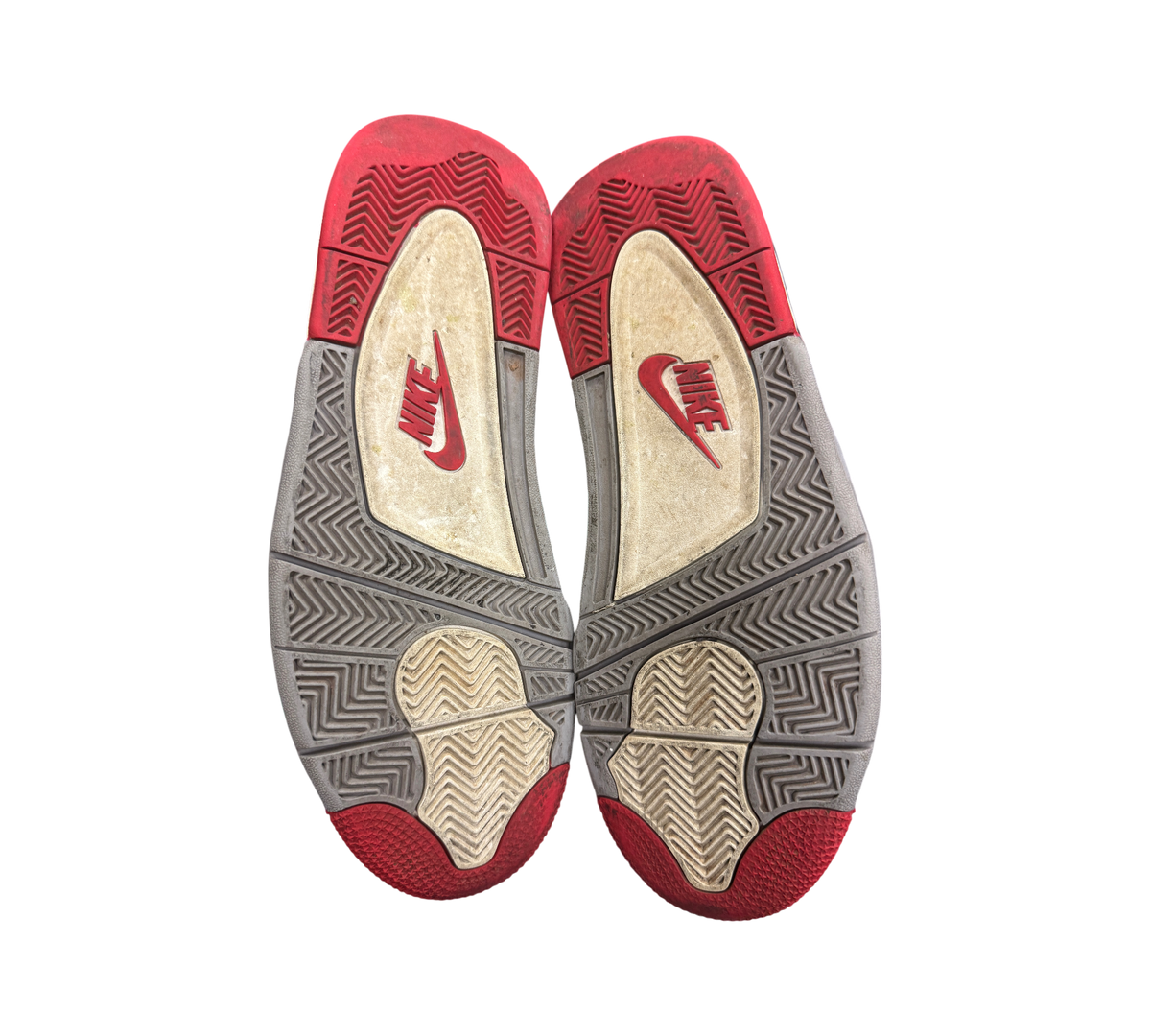 Used Jordan 4 Bred Reimagined sneakers showing red and grey rubber outsoles with Nike branding at Genesis Boutique