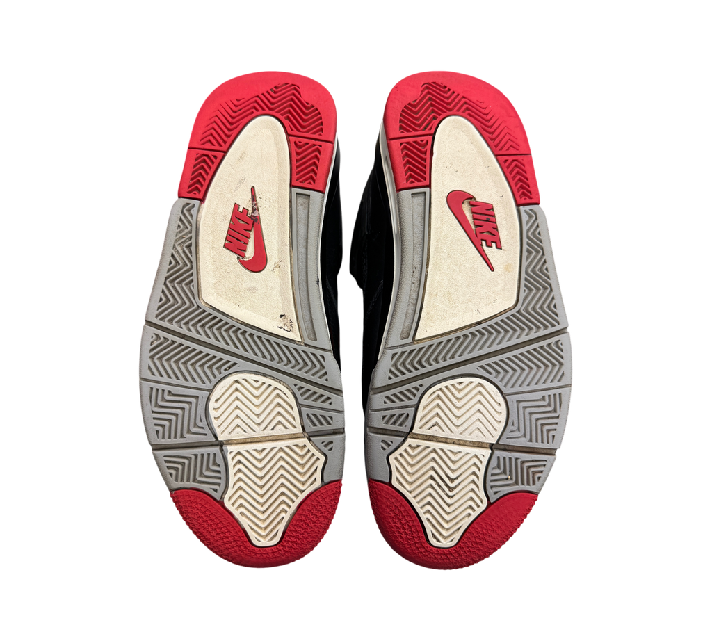 Genesis Boutique Jordan 4 Bred Reimagined sneakers showing the red, grey, and white rubber outsoles with Nike branding.