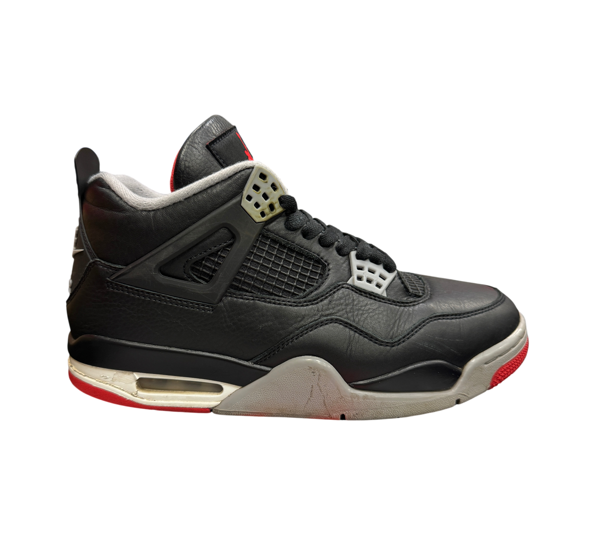 Genesis Boutique Jordan 4 Bred Reimagined sneakers in black leather with grey and red accents on a speckled box