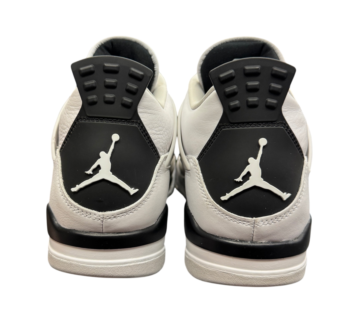 Genesis Boutique Jordan 4 Military Black sneakers showing the white and black heel tabs with Jumpman logos