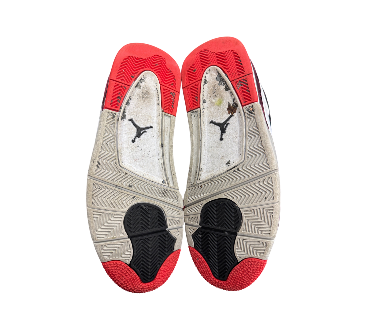 Genesis Boutique Jordan 4 Pale Citron sneakers showing worn red, white, and black rubber outsoles with Jumpman logo.