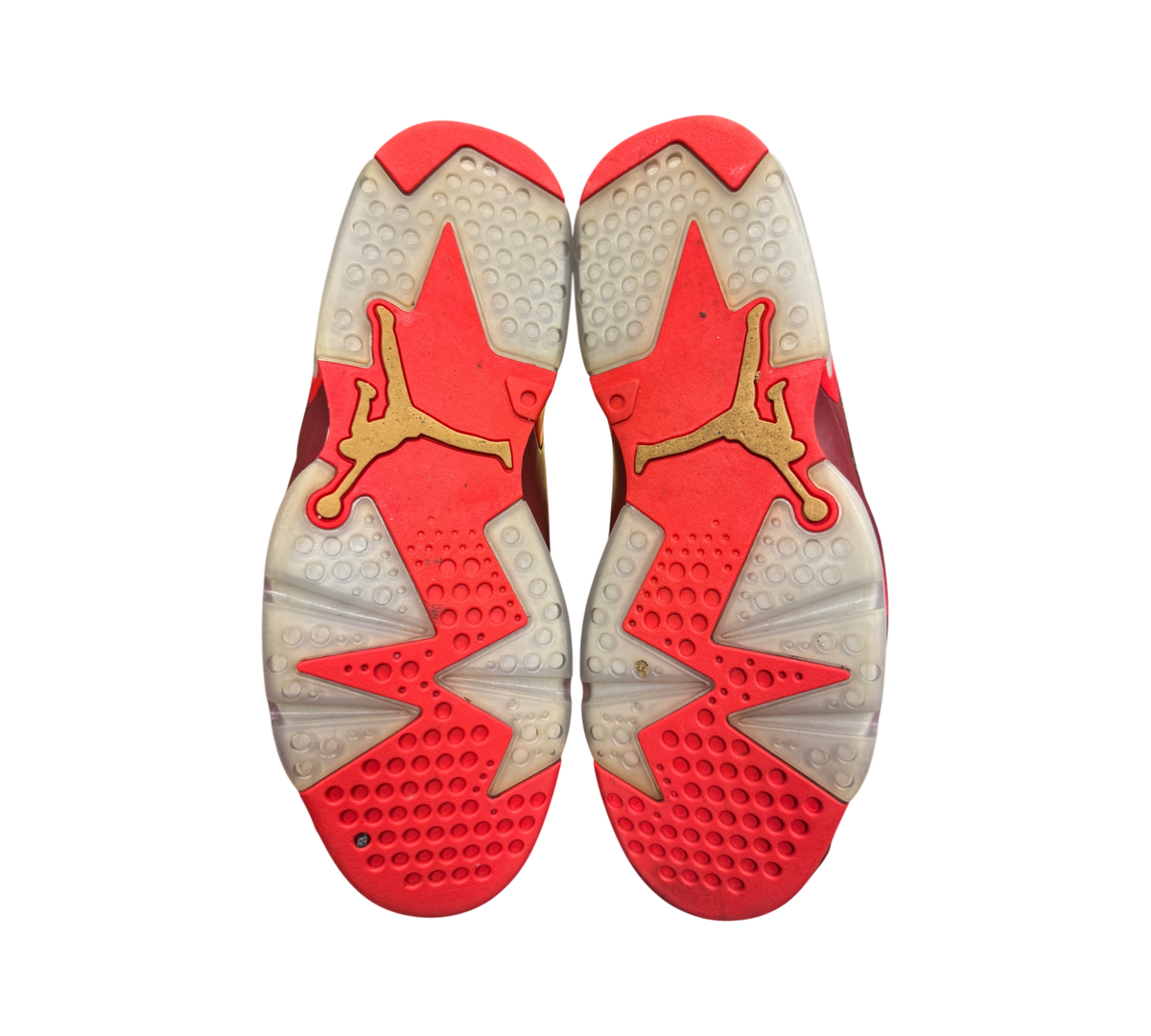 Genesis Boutique Jordan 6 Cigar sneakers showing the red and translucent rubber outsoles with gold Jumpman logos.