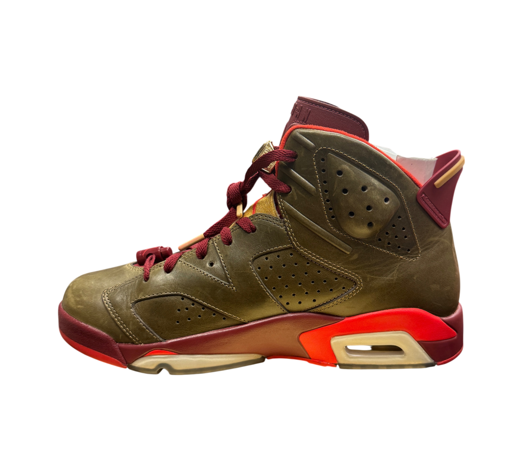 Genesis Boutique Jordan 6 Cigar sneakers in raw umber and team red leather with gold accents on a display box