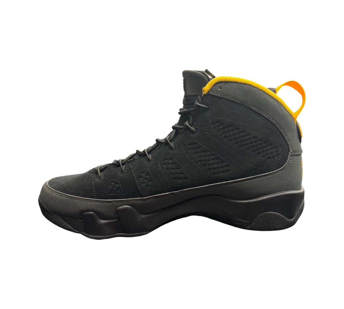 Genesis Boutique Jordan 9 Charcoal sneakers in black nubuck with yellow accents on the collar and heel pull tab.