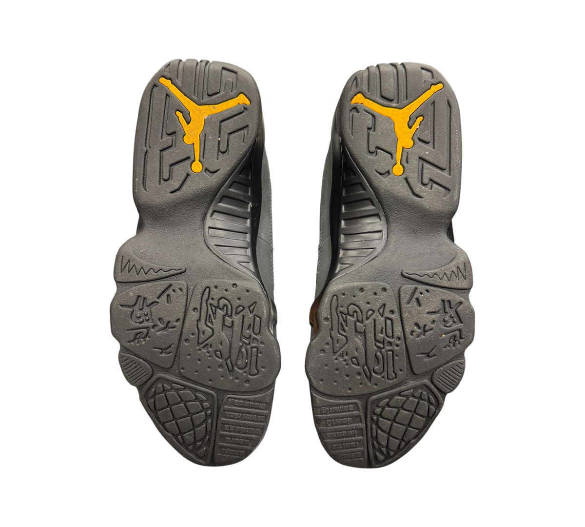 Genesis Boutique Jordan 9 Charcoal sneakers showing the black rubber outsoles with yellow Jumpman logos