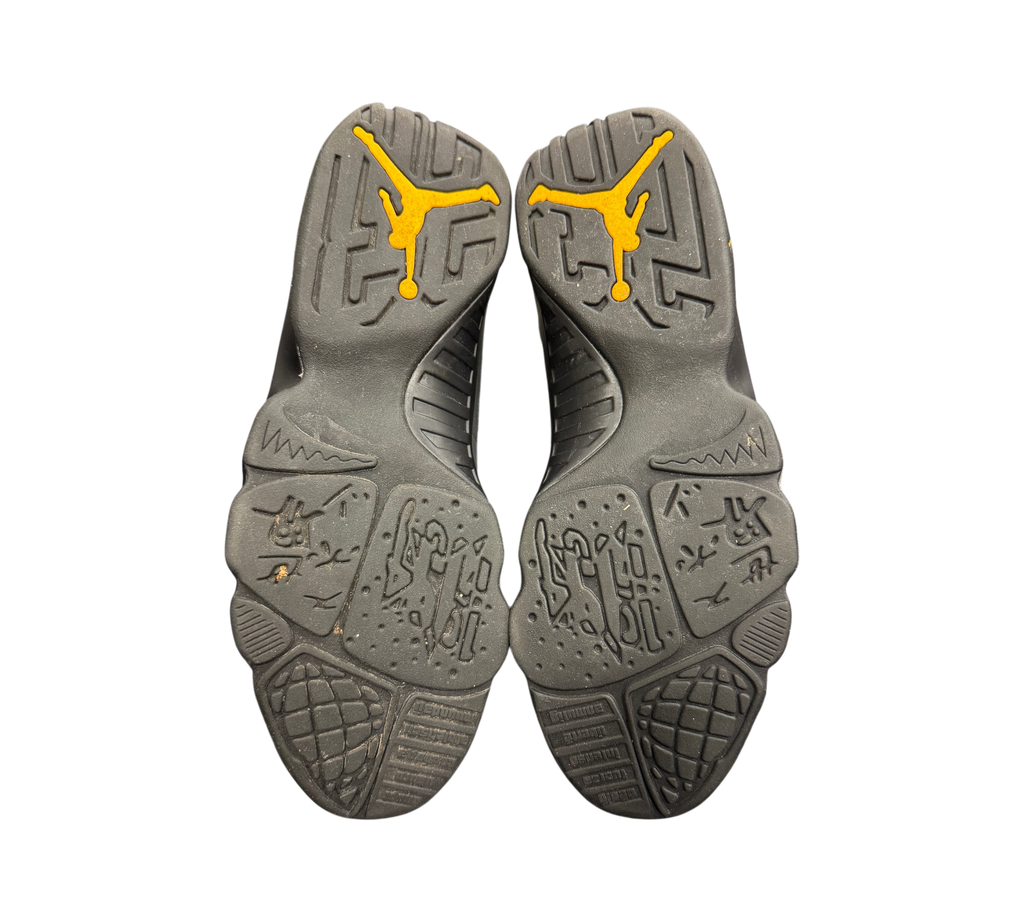 Genesis Boutique Jordan 9 Charcoal sneakers showing the black rubber outsoles with yellow Jumpman logos