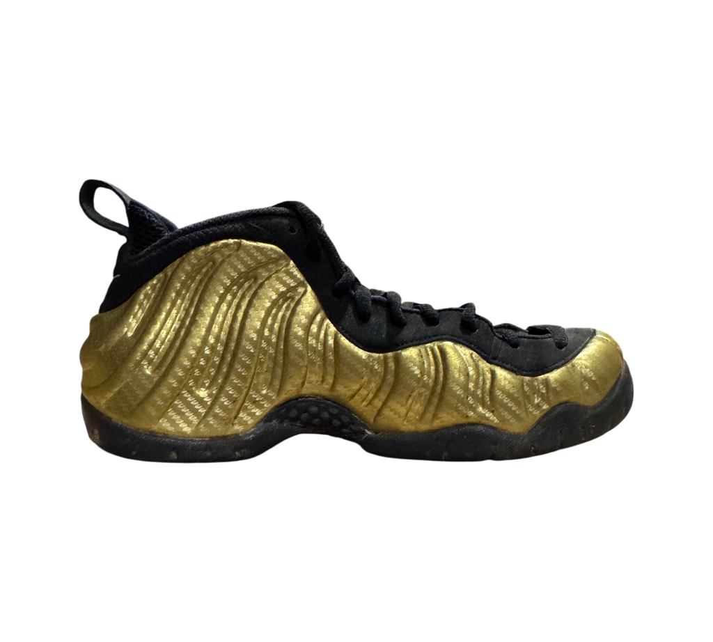 Genesis Boutique Nike Air Foamposite 1 Gold sneakers featuring a metallic gold molded upper and black accents.