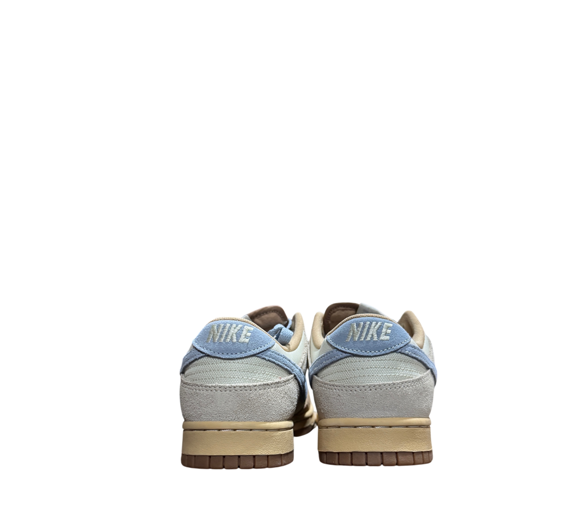 Genesis Boutique Nike Dunk Low Sanddrift Light Armory Blue sneakers, rear view showing textured heel and blue tabs.
