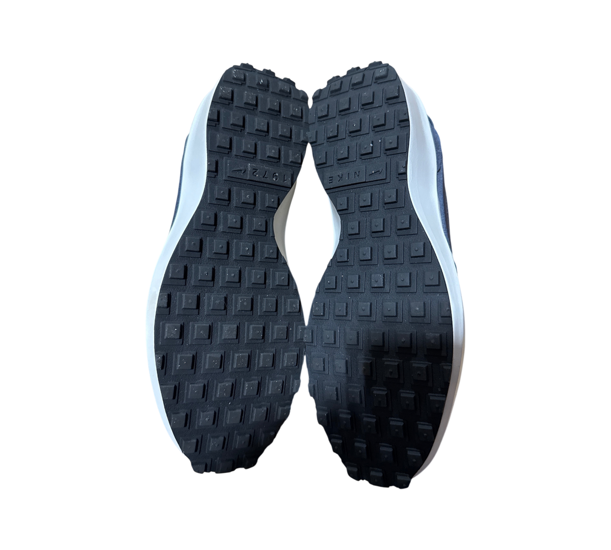 Genesis Boutique used Nike Waffle Debut SE sneakers showing the black rubber waffle tread outsoles