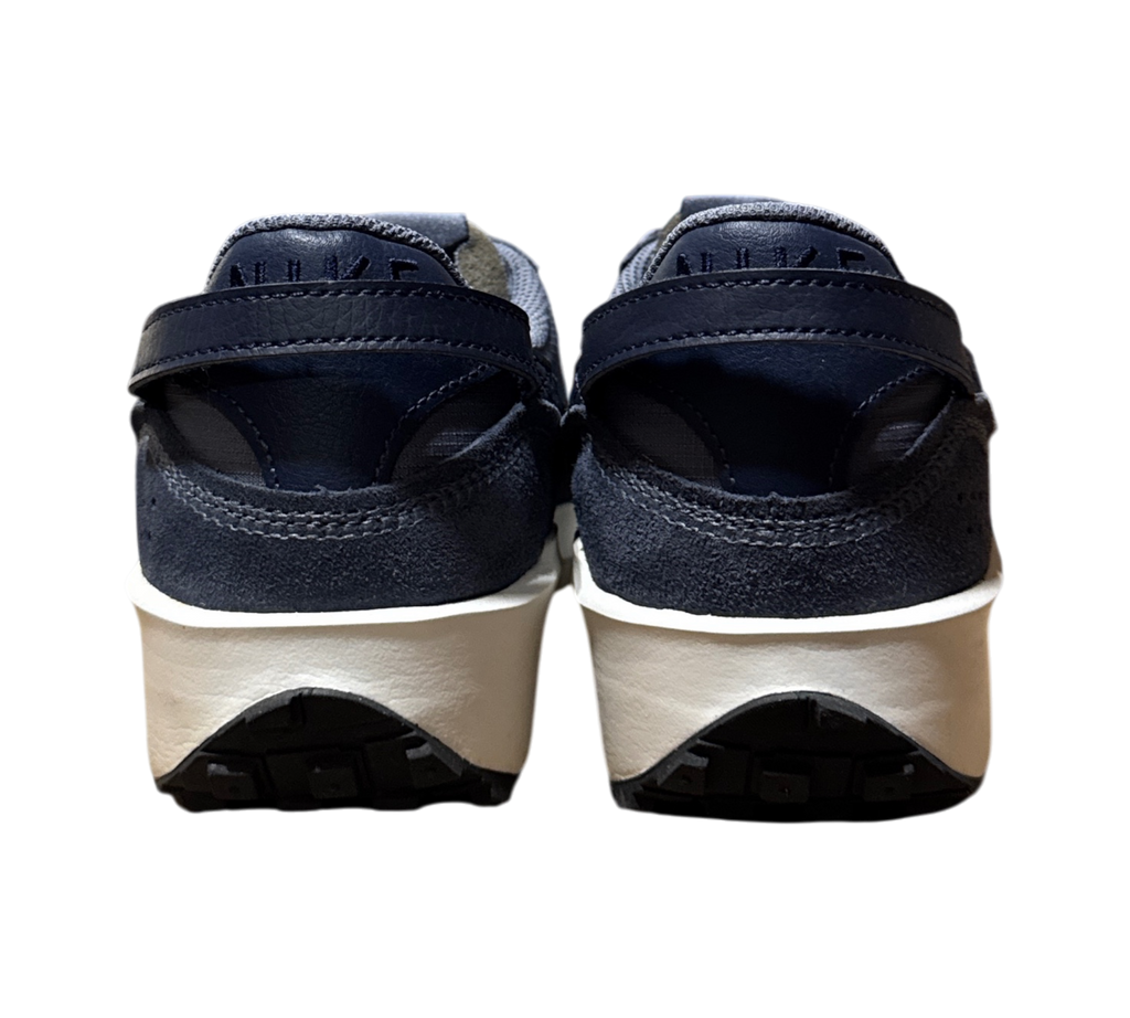 Genesis Boutique Nike Waffle Debut SE sneakers in light carbon and obsidian blue, rear view showing white midsoles.