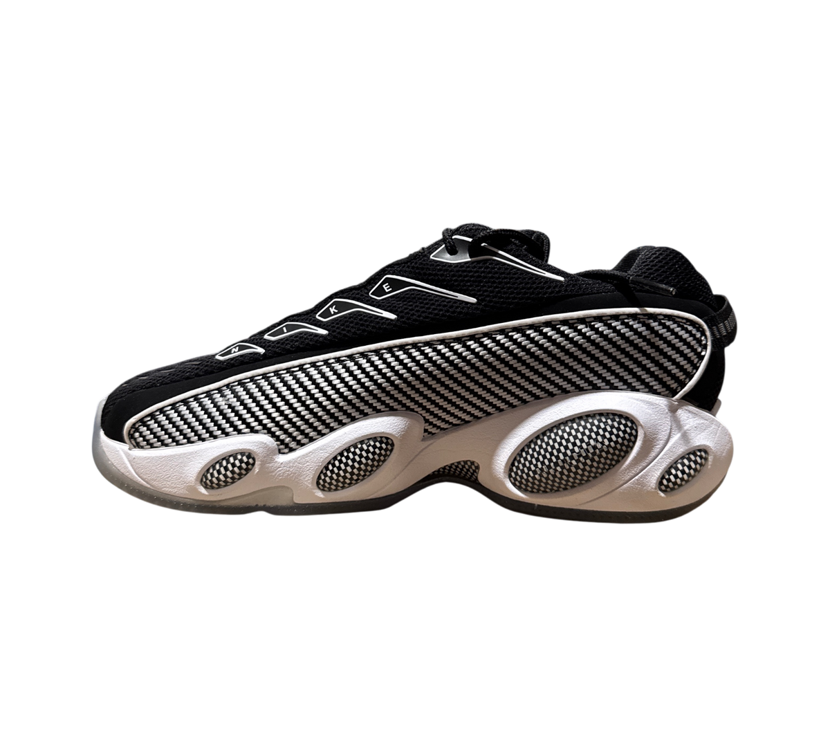 Genesis Boutique NOCTA x Nike Glide sneakers in black and white with a textured carbon fiber style side panel