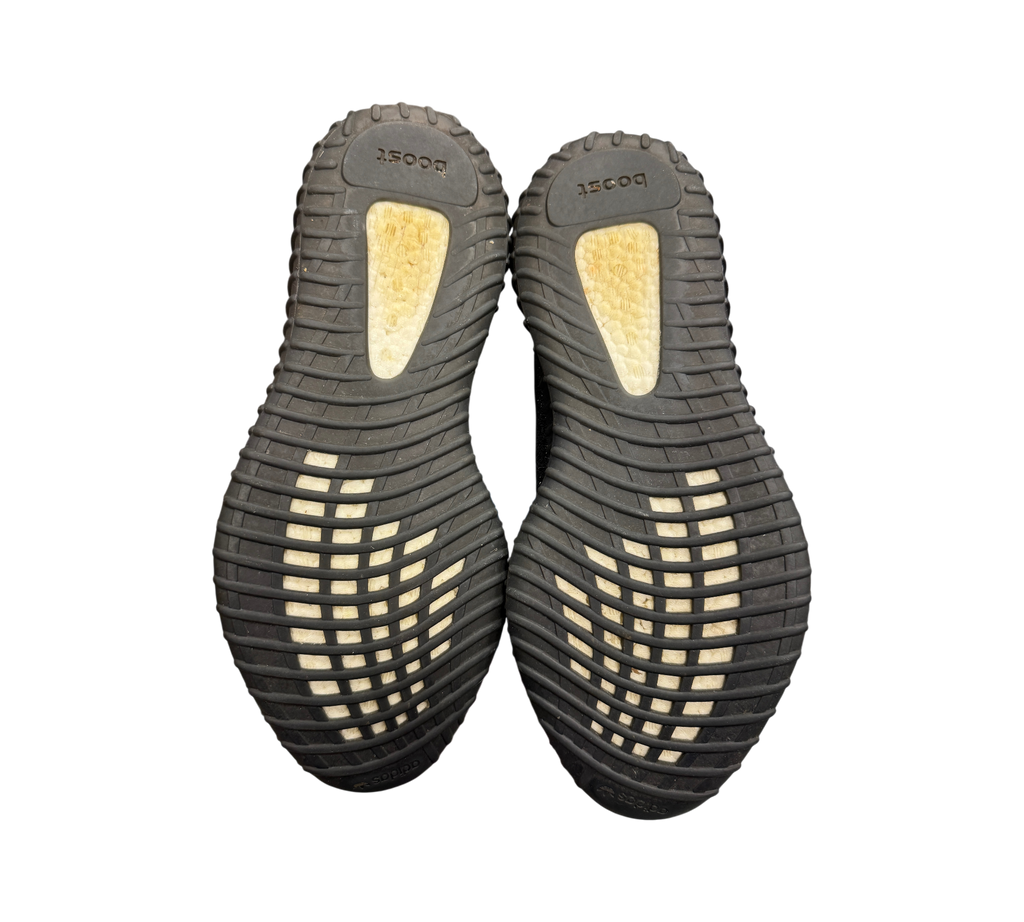 Genesis Boutique used Yeezy 350 Oreo sneakers showing the black rubber outsoles with white Boost cushioning inserts.