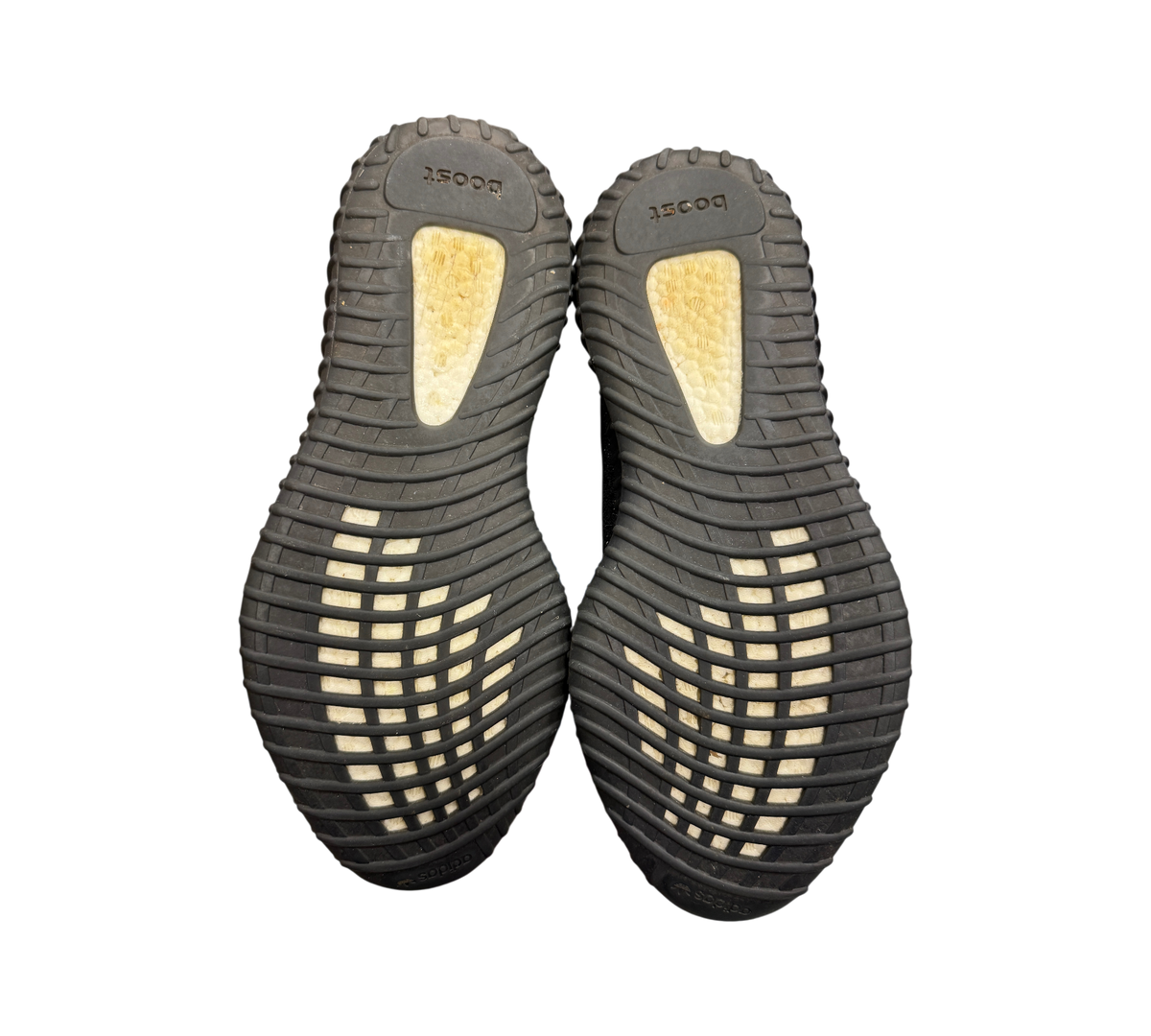 Genesis Boutique used Yeezy 350 Oreo sneakers showing the black rubber outsoles with white Boost cushioning inserts.