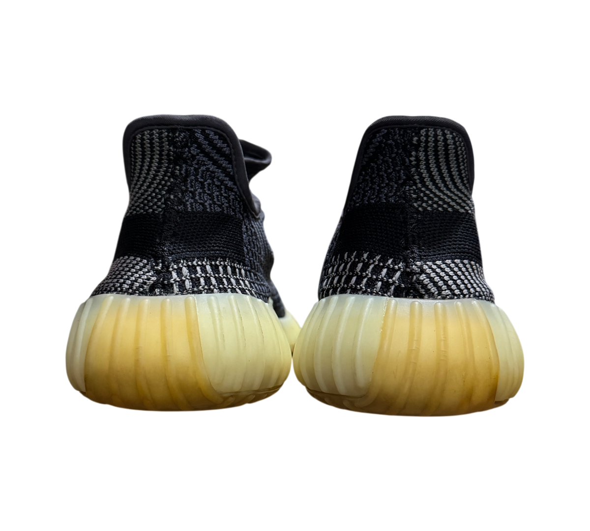 Genesis Boutique Yeezy 350 V2 Carbon sneakers showing the back heel view with black patterned knit and yellowed soles