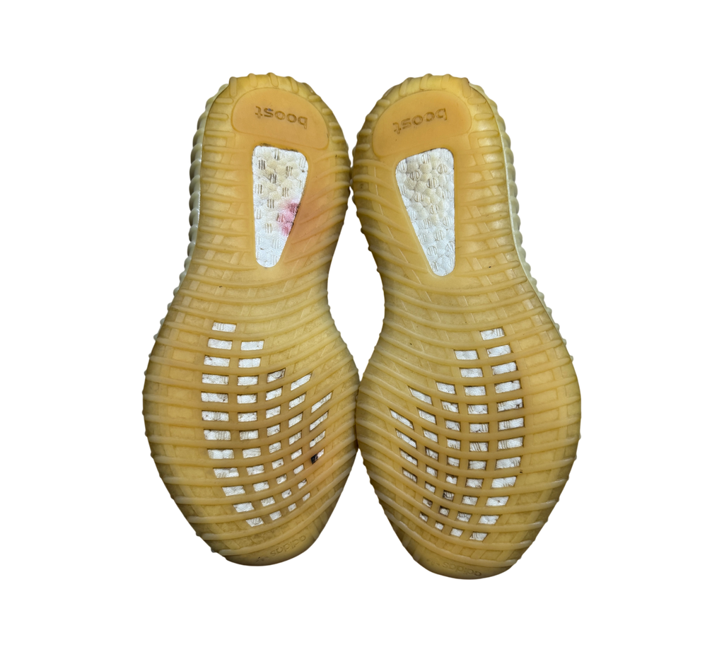 Genesis Boutique used Yeezy 350 V2 Carbon sneakers showing the yellowed rubber outsoles and Boost cushioning detail