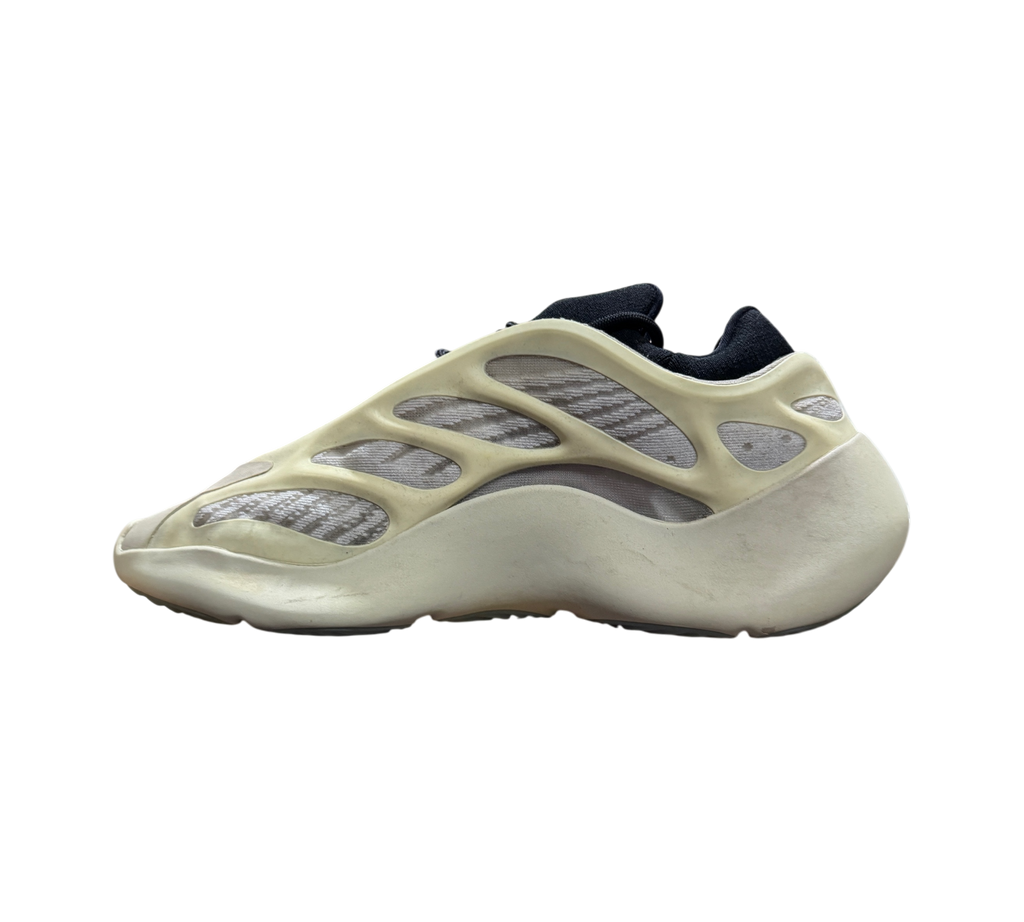 Genesis Boutique used Yeezy 700 Azael sneakers in off-white and black, side profile view on a cardboard box.